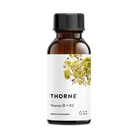 Thorne Vitamin D + K2 dietary supplement bottle on a green background